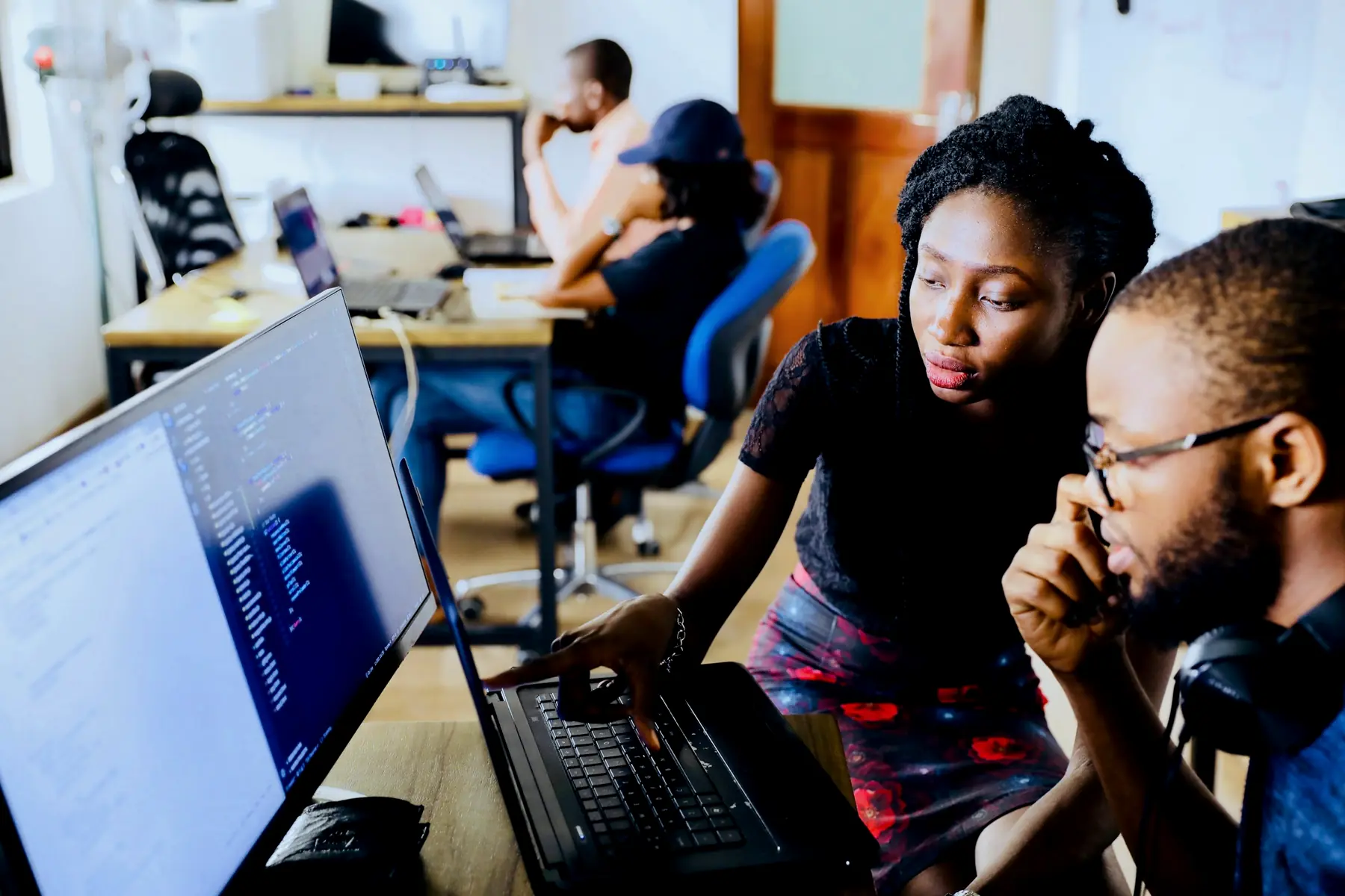 Engineers working through code together at a screen